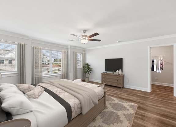 Another view of the spacious primary suite showcasing a grand bed and modern ceiling fan.