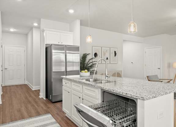 A modern kitchen with a white color scheme and a marble countertop.