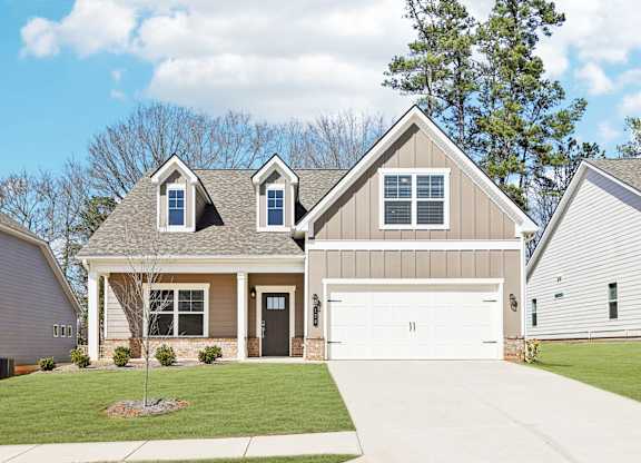 A two-story house with a garage and a driveway.