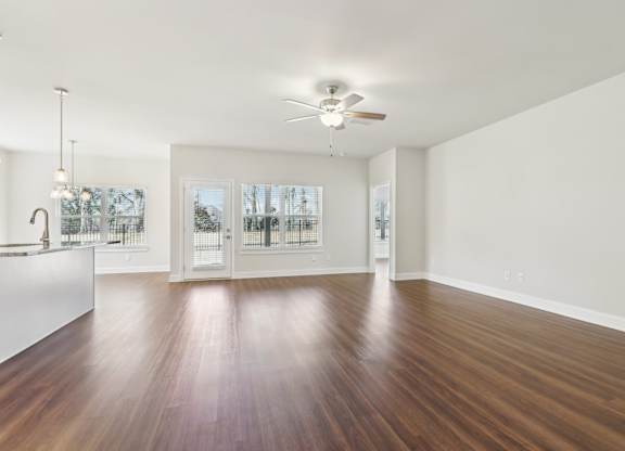 A room with a ceiling fan and a wooden floor.