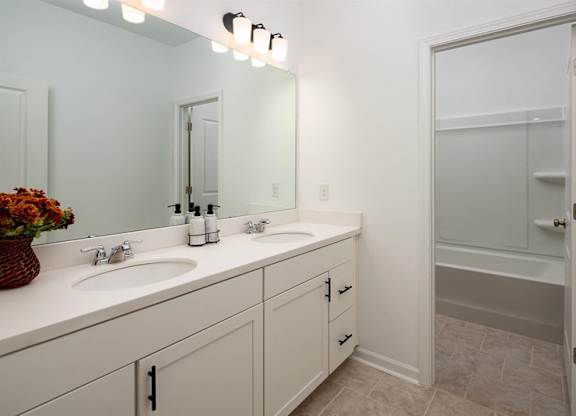 Alternate view of the third bathroom showcasing a double vanity and a tub-shower combination.