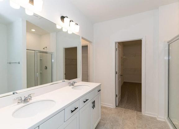 Primary bathroom with double vanity, and walk-in shower.