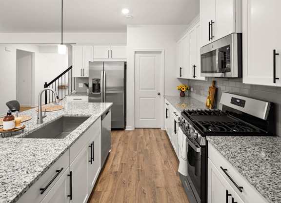 Spacious kitchen with an island, ample storage, stainless steel appliances and view into the living room.