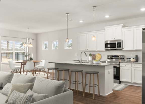A modern kitchen with a bar area and a dining table.