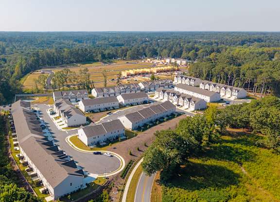 Community aerial showcasing homes, streets, and green spaces from above.