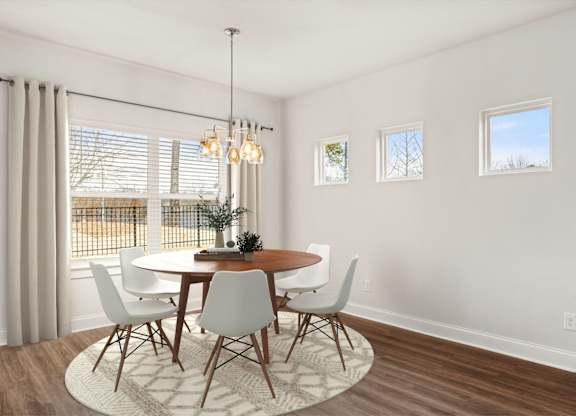 A dining room with a round table and chairs.