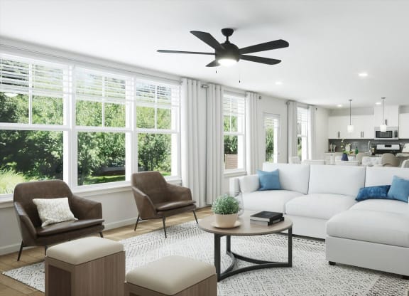 a living room with white furniture and a ceiling fan