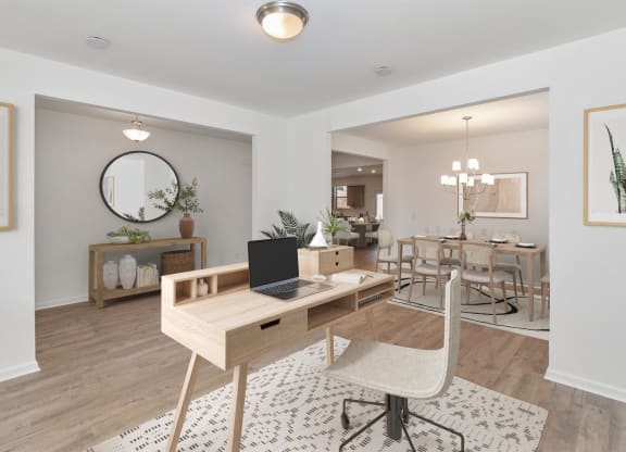 a living room with a desk and a laptop