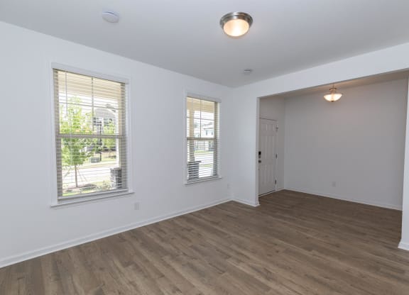 an empty living room with white walls and wood floors