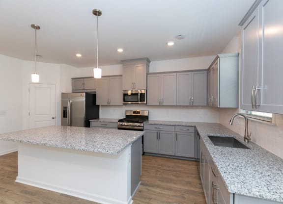 a large kitchen with granite counter tops and stainless steel appliances