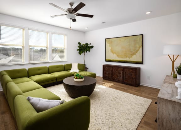 a living room with green couches and a round coffee table