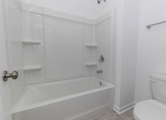 a white bathroom with a tub and a toilet
