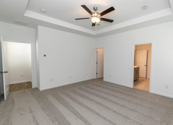 the living room of an empty house with a ceiling fan