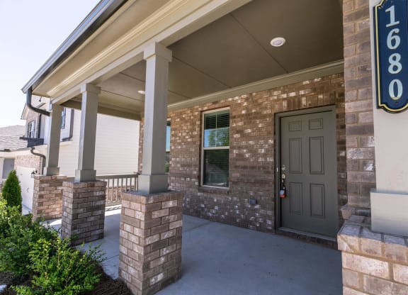 a front door of a brick building with a porch