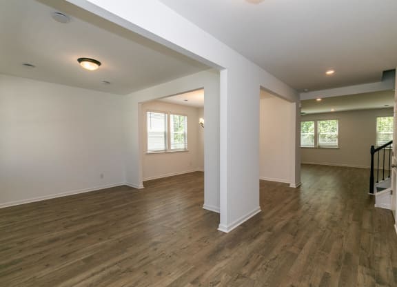 an empty room with a wooden floor and rainbow colored lights