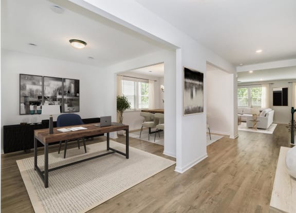 a large living room with a desk and a rug