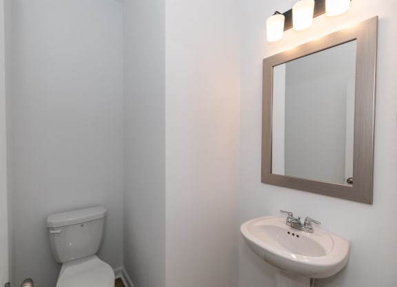 a bathroom with a toilet and a sink and a mirror