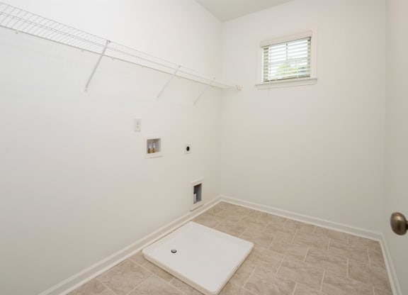 a room with a white wall and a window and a white rug