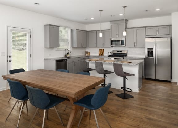 a kitchen with stainless steel appliances and a wooden table