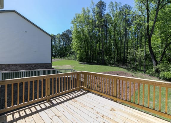 a deck with a view of a yard and trees