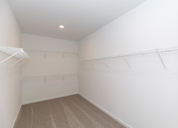 a room with white walls and a closet with white hangers