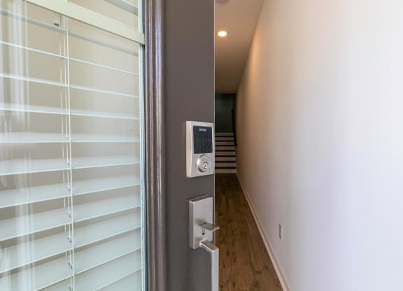 the door to the hallway of a house with white blinds on the window
