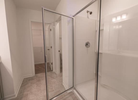 a white bathroom with a shower and a tub