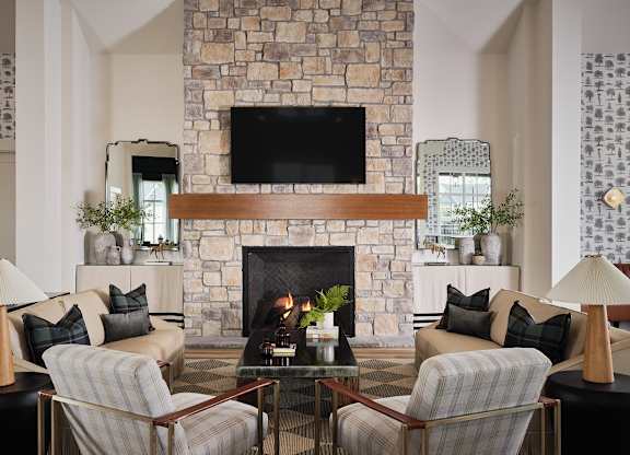 Inviting clubhouse living room featuring cozy seating, a fireplace, and a large TV for entertainment.