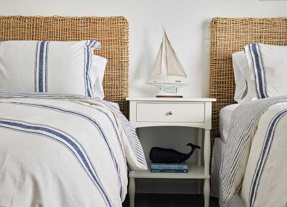 Charming third bedroom featuring two twin beds and a nightstand adorned with a sailboat accent.