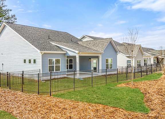 A white house with a black fence in front of it.