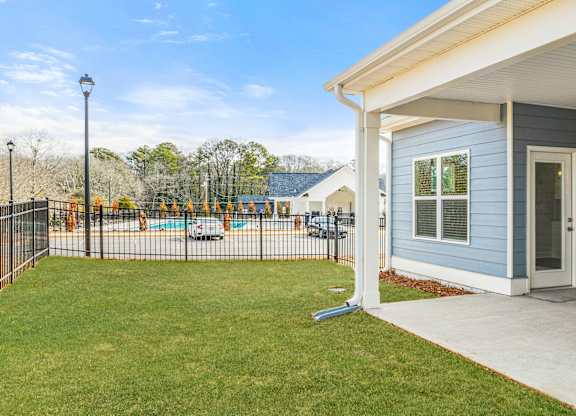 A blue house with a white porch and a black fence.