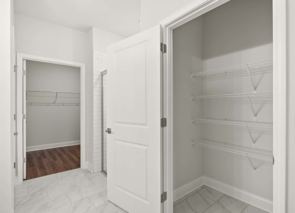 A white kitchen pantry with a door open.
