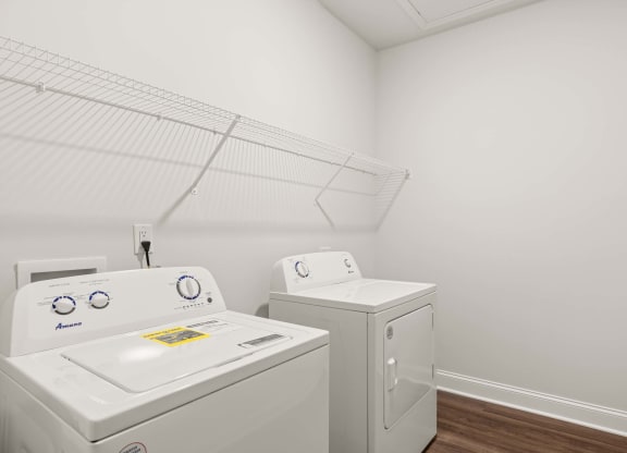 A white washing machine and dryer in a small laundry room.
