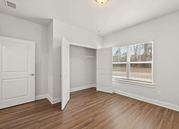 a room with white walls and a wooden floor and a glass shower