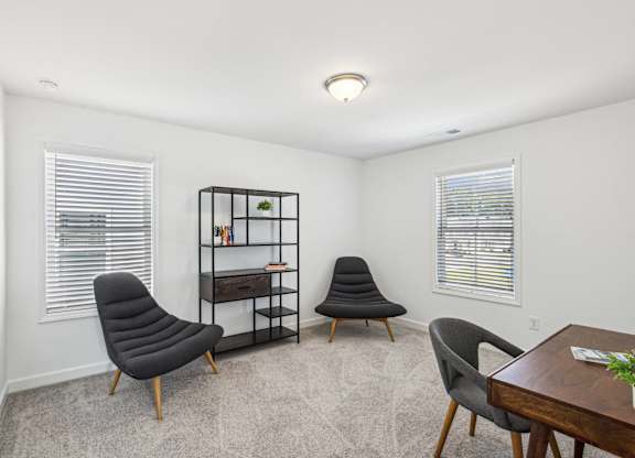 two chairs and a table in a room with two windows
