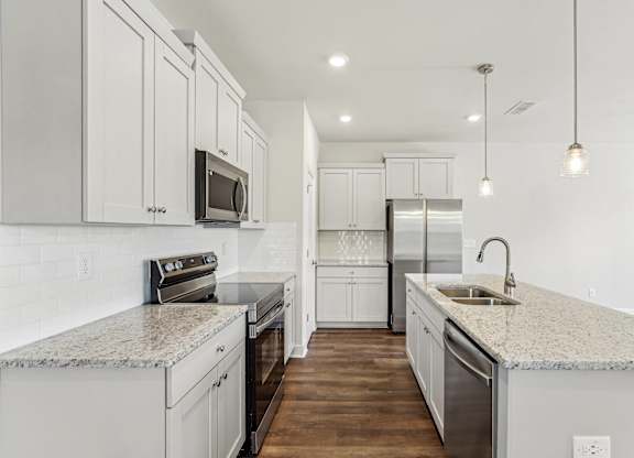 a white kitchen with marble counter tops and white cabinets