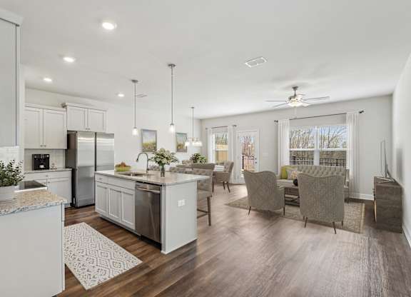 the gathering room and kitchen of a new home with an open floor plan