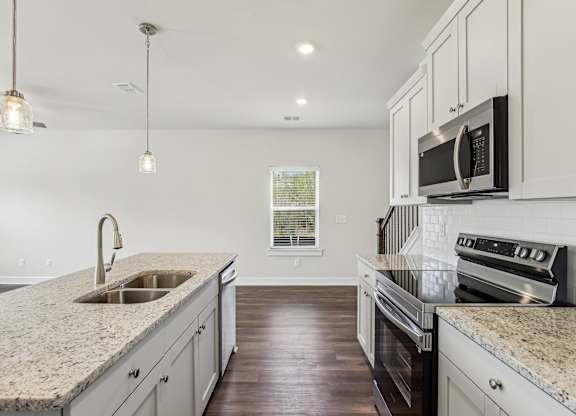 a kitchen with granite counter tops and white cabinets