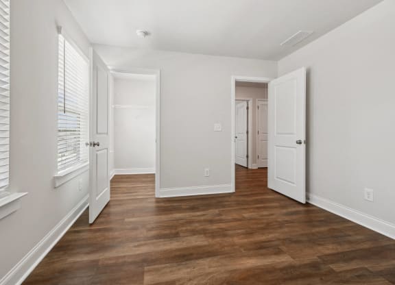 a living room with a hard wood floor and white walls