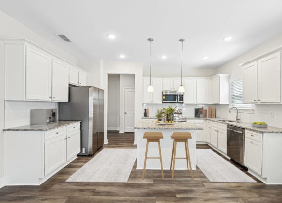 a large kitchen with white cabinets and stainless steel appliances