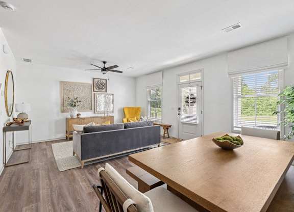 Living room with large couch, accent chairs, and windows.