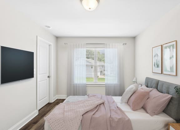 a bedroom with a bed and a tv on the wall