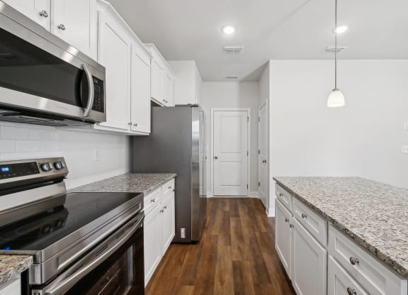 4-bedroom single family home with spacious kitchen. Open-floor plan concept with kitchen island, ample storage and bar seating.