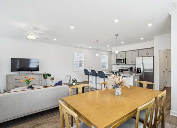 a living room and dining room with a wooden table