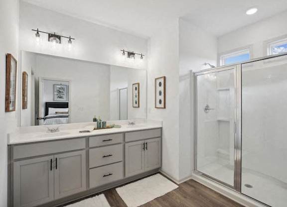 Primary bathroom with double vanity, and walk-in shower.