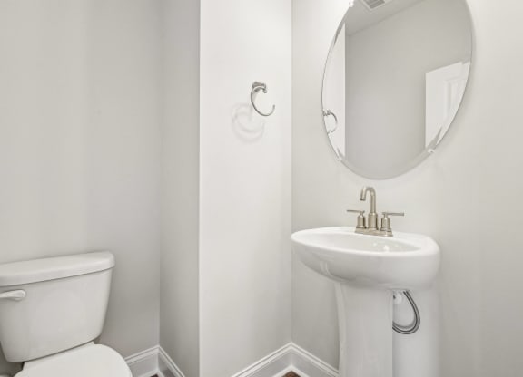 a white bathroom with a white toilet and a white sink