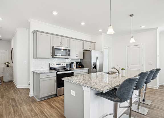 a kitchen with white cabinets and a marble counter top