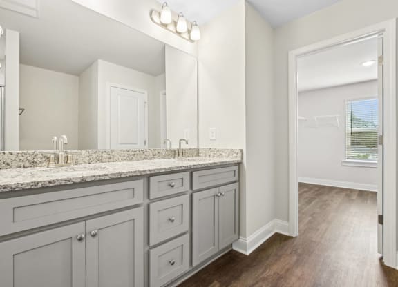 a white bathroom with a large mirror and a large sink