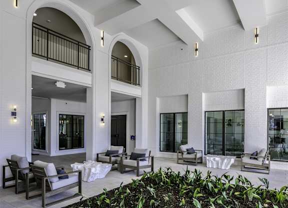 A patio with chairs and plants.