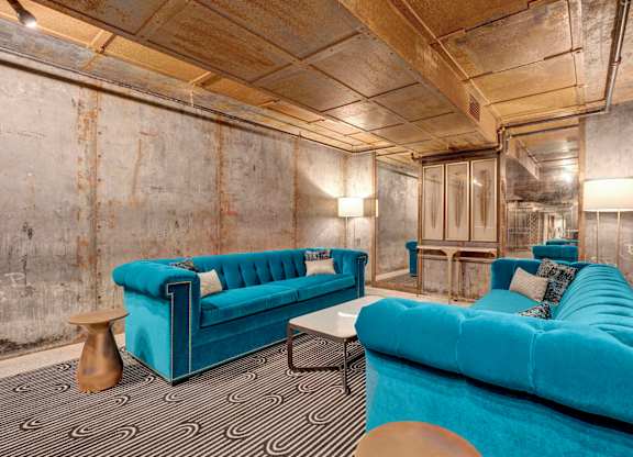 a living room with blue couches and a black and white carpet at Metro67, Tennessee, 38103